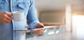Male hands holding white digital tablet and cup of coffee Royalty Free Stock Photo