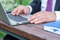 Close-up of male hands on the laptop keyboard. Online business meeting in the park Royalty Free Stock Photo