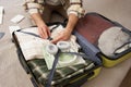 Close up of male hands, man fastening clothes inside suitcase, packing his belongings in luggage, going on holiday Royalty Free Stock Photo