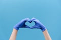 Close up of male hands in medical protection gloves making heart symbol as a way to show thank gratitude to doctors and nurses