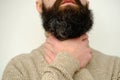 Close-up of male hands on neck, young man holds throat, guy with beard 30 years old is sick, concept of health, diagnosis Royalty Free Stock Photo