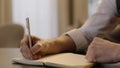 Close-up of male hands and notebook of unidentified young writer.