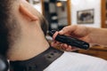 Close-up male hands with safety razor shave beard of customer at barbershop. Beauty, selfcare, style, fashion and male Royalty Free Stock Photo