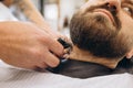 Close-up male hands with safety razor shave beard of customer at barbershop. Beauty, selfcare, style, fashion and male Royalty Free Stock Photo