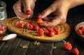 Close-up of male hands sorting strawberries on a kitchen cutting board. Preserving strawberries with sugar in a jar. Preparing a