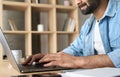 Close up male hands typing on laptop keyboard on desk indoors at home office. Royalty Free Stock Photo