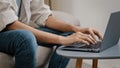 Close-up male hands typing on laptop keyboard. Unrecognizable guy unknown business man in jeans casual shirt sitting on Royalty Free Stock Photo