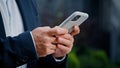 Close up male hands typing texting browsing mobile phone. Unrecognizable unknown man businessman in formal suit working