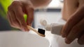 Close up male hands unrecognizable man guy squeeze medical whitening toothpaste on eco bamboo toothbrush preparing teeth Royalty Free Stock Photo