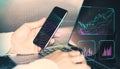 Close up of male hands using cellphone and laptop keyboard with creative glowing business chart and ai binary code nodes on blurry