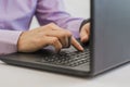 Close-up of male hands using laptop at office, man's hands typing on laptop keyboard in interior,side view of businessman Royalty Free Stock Photo