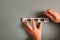 Close up of male hands using spirit level and pencil to mark straight line on wall. Home renovation concept Royalty Free Stock Photo