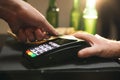 Close up of male hold in hand wireless modern bank payment terminal to process acquire credit card payments black card