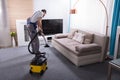 Janitor Cleaning Carpet With Vacuum Cleaner Royalty Free Stock Photo