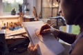 Close Up Of Male Jeweller Sketching Out Design For Ring In Studio