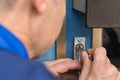 Close-up Of Male Lockpicker Fixing Door Handle At Home