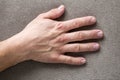 Close-up of male masculine hand with rough skin and short fingernails resting on flat copy space background, top view. Manual