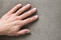 Close-up of male masculine hand with rough skin and short fingernails resting on flat copy space background, top view. Manual