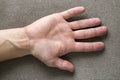 Close-up of male masculine hand with rough skin and short fingernails resting on flat copy space background, top view. Manual