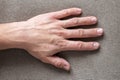 Close-up of male masculine worker hand with rough skin and short fingernails resting on flat copy space background, top view.