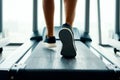 Close up male muscular feet in sneakers running on the treadmill at gym Royalty Free Stock Photo