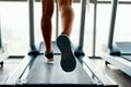 Close up male muscular feet in sneakers running on the treadmill at gym Royalty Free Stock Photo