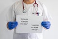 Close-up of a male nurse holding a sign.