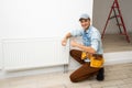 Close-up Of Male Plumber Fixing Thermostat Using Wrench At Home. Royalty Free Stock Photo