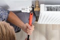 Male Plumber Fixing Thermostat Using Wrench Royalty Free Stock Photo