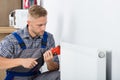 Male Plumber Fixing Thermostat Using Wrench Royalty Free Stock Photo