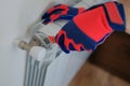 Male plumber hands in gloves installing or repairing heating radiator using wrench