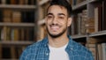 Close-up male portrait young handsome happy man standing in library looking at camera smiling healthy toothy smile Royalty Free Stock Photo