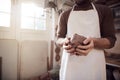 Close Up Of Male Potter Wearing Apron Holding Lump Of Clay In Ceramics Studio