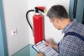 Professional Checking A Fire Extinguisher Royalty Free Stock Photo