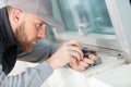 close-up male repairman fixing window with screwdriver Royalty Free Stock Photo