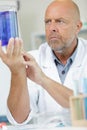 close-up male researcher holding flask with blue liquid Royalty Free Stock Photo