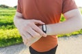 Close-up of Male runner jogging outside looking at his wearable fitness tracker outside.