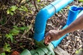 Close up of male`s hand fixing water pump pipe flow equipment agriculture. Royalty Free Stock Photo