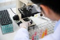 Close-up, Male scientist examining a virus specimen under the microscope in the lab Royalty Free Stock Photo