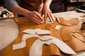 Close up of a male shoemaker cutting leather textile