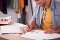 Close Up Of Male Student Or Business Owner Working In Fashion Sketching Designs In Studio