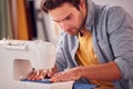 Close Up Of Male Student Or Business Owner Working In Fashion Using Sewing Machine In Studio