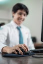 close up of a male student's hand sitting holding a computer mouse while studying Royalty Free Stock Photo