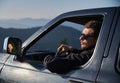 Man with sunglasses driving black car in the mountains. Royalty Free Stock Photo