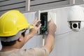 Close Up Of Male Technician Fixing CCTV Camera On Wall