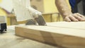 Close-up of male worker`s hands working with the circular saw and cutting large boards of wood in a workshop or plant Royalty Free Stock Photo