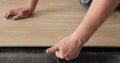 Close-up of a man in an apartment laying laminate on the floor. Floor in a Home. Closeup on male hands. Royalty Free Stock Photo