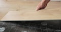 Close-up of a man in an apartment laying laminate on the floor. Floor in a Home. Closeup on male hands. Royalty Free Stock Photo