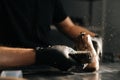 Close-up of man in black latex gloves cleaning shoe brush, brushing dust and dirt off with finger.