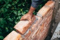 Close up of man, industrial bricklayer installing bricks on construction site